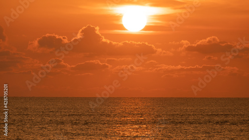 Beautiful sunrise or sunset over the ocean in summer. Gold sky with sunlight and clound above the sea. Nature  landscape  seascape background.