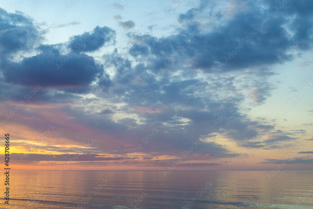 Summer mood. Beautiful colorful sunset over Baltic sea in Jurmala resort, Latvia. Warm evening on beach. Scenery view.