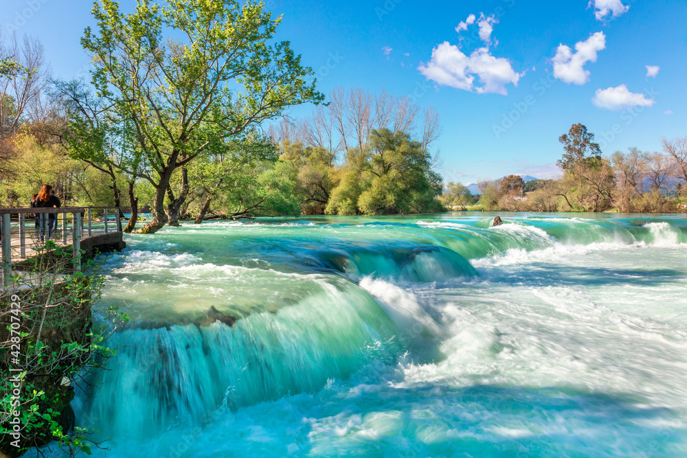 Fototapeta premium Beautiful natural landscape of Manavgat waterfall in national park on sunny spring day. Unique azure water color with splashes, Side, Antalya,Turkey