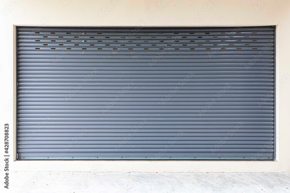 The gray roller shutter door of the store is closed The gray roller shutter door of the store is closed