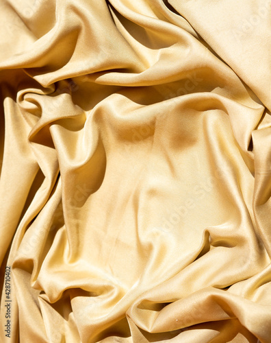 yellow fabric texture. wavy textile rippled from top point of view. luxurious material for exclusive background use. creative decoration element.