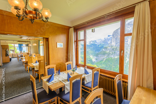 Modern dining room in luxury restaurant with fantastic swiss alps mountain view.