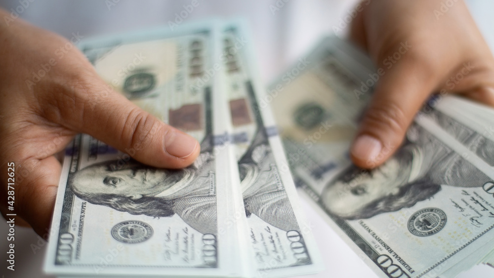 Businessman hand holding dollar bank notes, analysing growth profit from return on investment in financial trade funds and currency exchange. Managing success financial investment in economic trends. Businessman hand holding dollar bank notes, analysing growth profit from return on investment in financial trade funds and currency exchange. Managing success financial investment in economic trends.