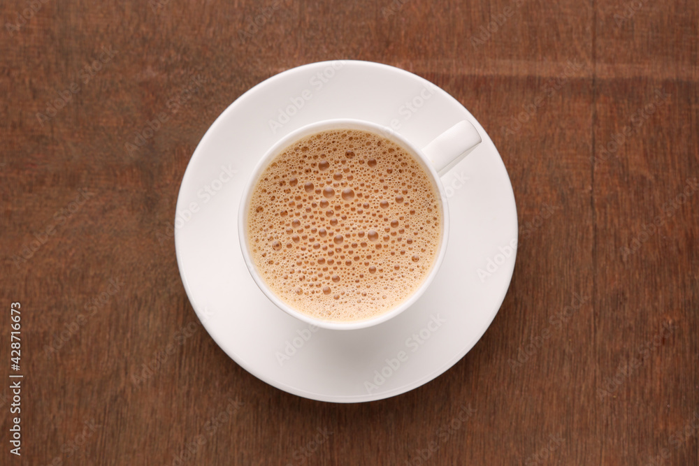 Top view of Indian Chai or traditional beverage milk tea and spices Kerala India. Cup of organic ayurvedic or herbal drink India, good in winter for immunity boosting. Top view of Indian Chai or traditional beverage milk tea and spices Kerala India. Cup of organic ayurvedic or herbal drink India, good in winter for immunity boosting.