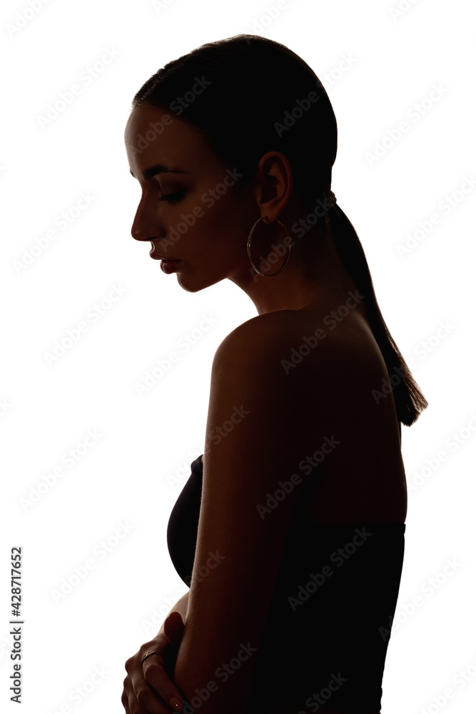 Fototapeta premium Woman silhouette. Female abuse. Gender discrimination. Dark contrast outline profile portrait of depressed hurt embarrassed victim lady looking down isolated on white background.