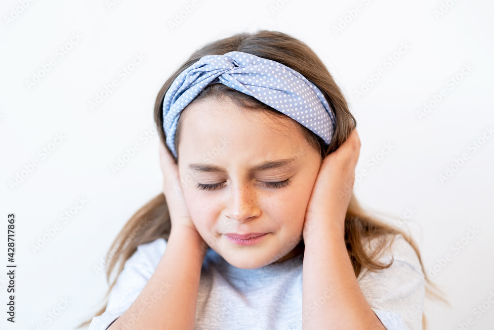Child headache. Stress anxiety. Failure regret. Portrait of disturbed disappointed suffering small girl clutching head covering ears with closed eyes isolated on white background. Child headache. Stress anxiety. Failure regret. Portrait of disturbed disappointed suffering small girl clutching head covering ears with closed eyes isolated on white background.