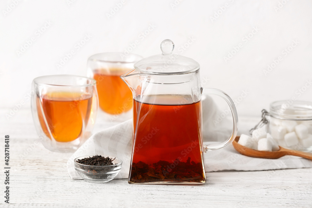 Teapot with hot tea and glasses on light background Teapot with hot tea and glasses on light background