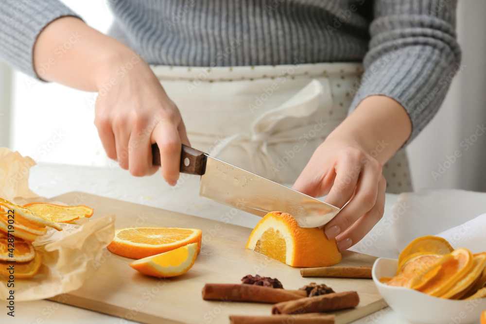 Woman cutting orange at table Woman cutting orange at table