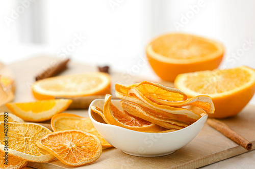 Fotografie Bowl with dried orange slices on light background