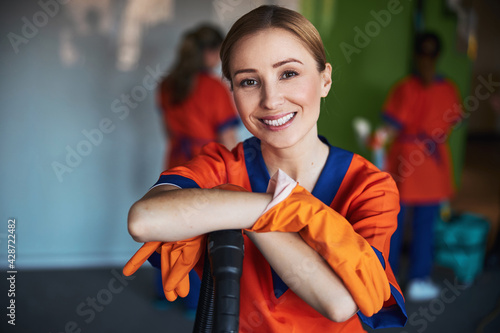 Pleased female janitor posing for the camera at work photo