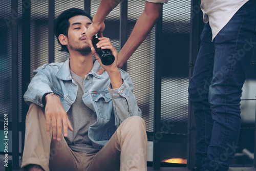 Drunk bearded young man and friend sitting on the street sidewalk after drinking lots of beer alcohol. Sad Depressed Insomnia Men. Protection and Treatment of Major Depressive Disorder Problem Concept photo