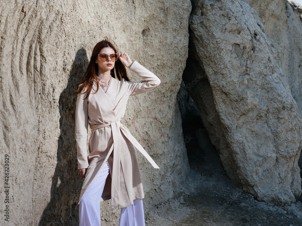 A woman in light clothes and near large stones in nature in the mountains A woman in light clothes and near large stones in nature in the mountains
