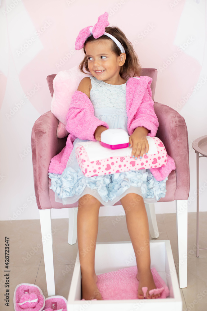 Little girl in spa center having a manicure and pedicure. Little girl in spa center having a manicure and pedicure.
