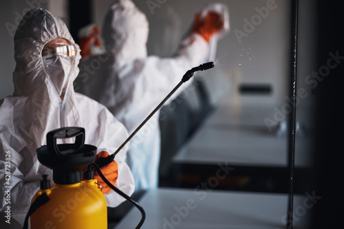 Φωτογραφία Two people in protective gear cleaning the glass walls
