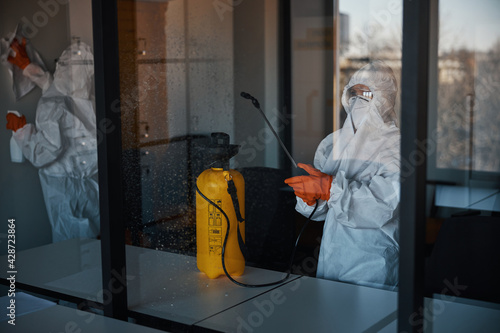 Cleaners in protective gear doing the antiviral disinfection