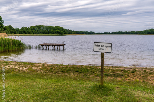 Sign: Baden auf eigene Gefahr (German for 'Bathing (Swimming) at your own risk') at the Penzliner See, Mecklenburg-Western Pomerania, Germany photo