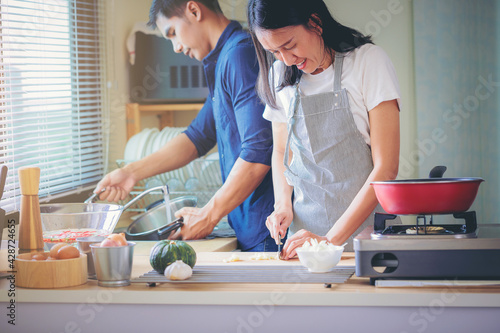 Happiness Asian couple cooking together in the kitchen at home. 
