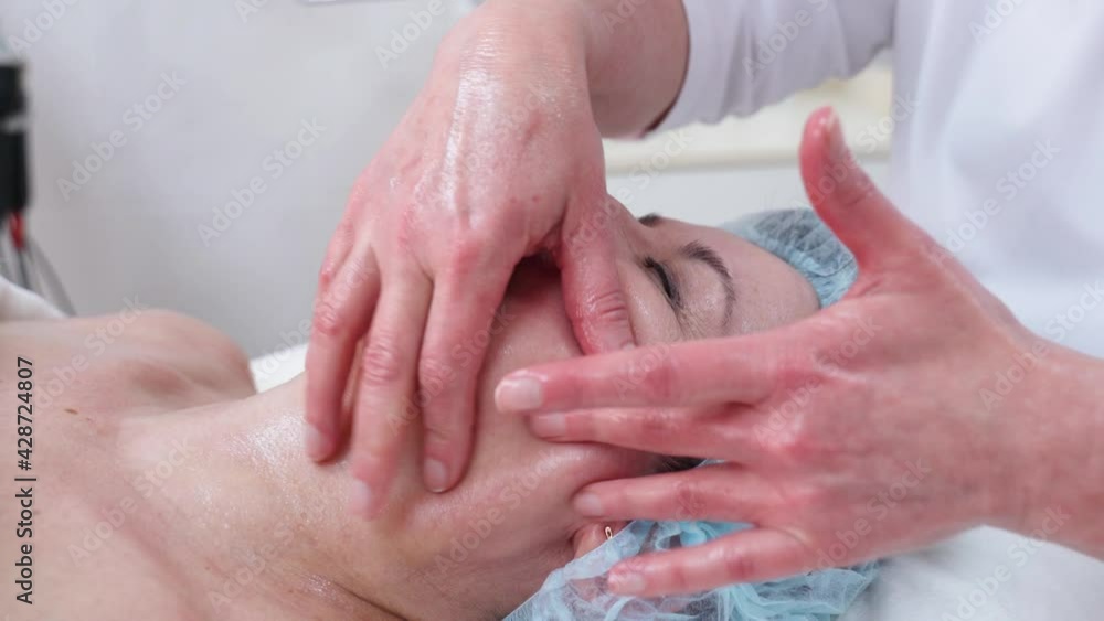 Face Massage in beauty spa salon. Female enjoying relaxing face massage in cosmetology spa centre. Body care, skin care, wellness, beauty treatment. Face Massage in beauty spa salon. Female enjoying relaxing face massage in cosmetology spa centre. Body care, skin care, wellness, beauty treatment.