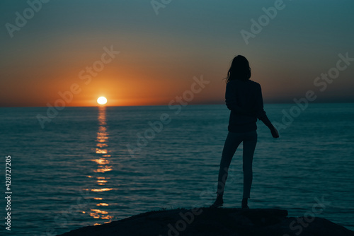 silhouette of woman on the sea at sunset and skyline beach sky