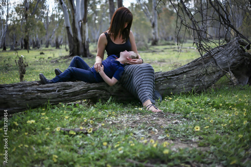 Boy lying on mother's lap sharing special moment of love and connection in the Australian bush © Caseyjadew