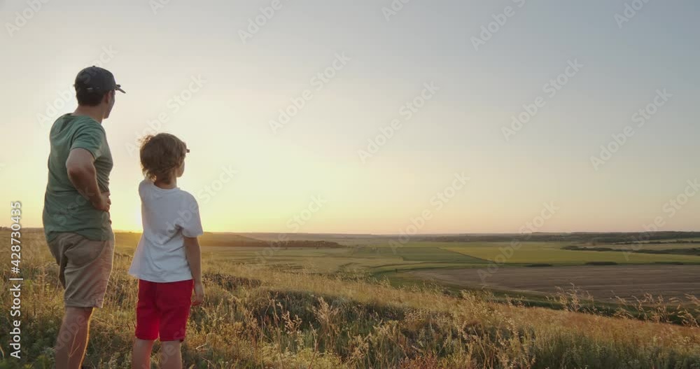 Happy child holding fathers hand walking outdoors Happy child holding fathers hand walking outdoors