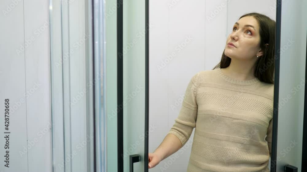 woman diagnoses shower stall with frosted glass and black frosted profile in the store. woman diagnoses shower stall with frosted glass and black frosted profile in the store.