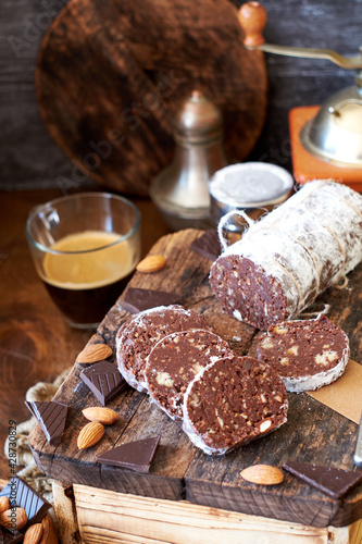 Chocolate salami on a wooden board on a wooden background. Side view.