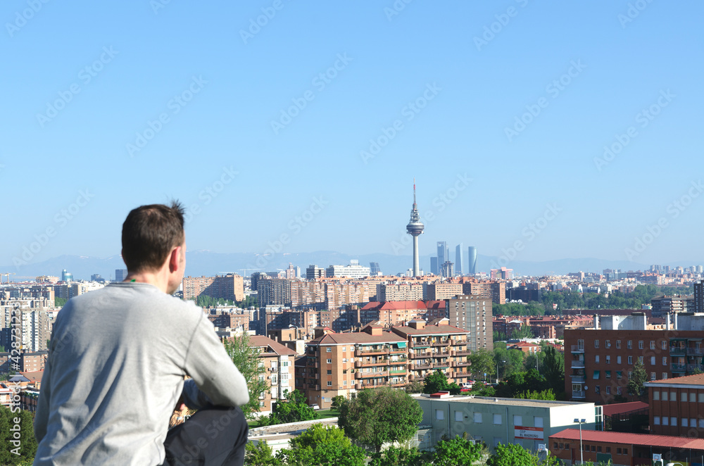 A man in a park, enjoying looking at the city. Madrid, Spain A man in a park, enjoying looking at the city. Madrid, Spain
