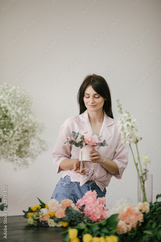 Young woman florist working in her flower studio, making beautiful bouquet using fresh plants and flowers. Young woman florist working in her flower studio, making beautiful bouquet using fresh plants and flowers.