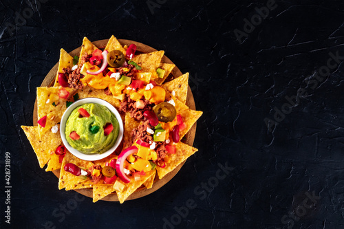 Mexican nacho chips with meat and guacamole photo