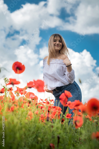 Fototapeta Naklejka Na Ścianę i Meble -  Happy young woman enjoying freedom at nature, poppy field