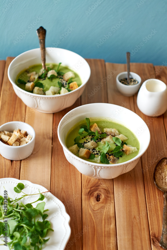 broccoli puree soup with sesame seeds, croutons and herbs. wooden background, side view broccoli puree soup with sesame seeds, croutons and herbs. wooden background, side view