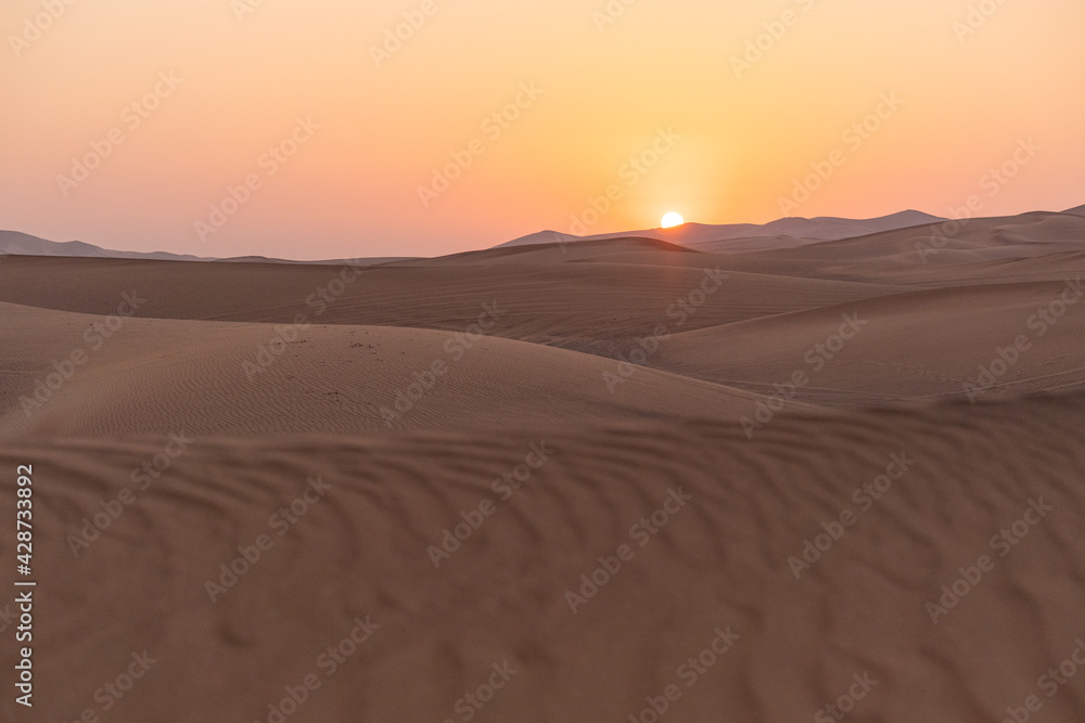 Landscape of desert dunes at sunset