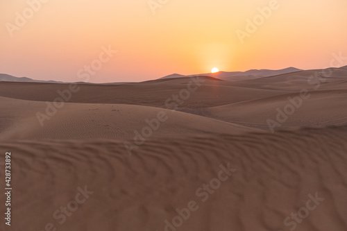 Landscape of desert dunes at sunset