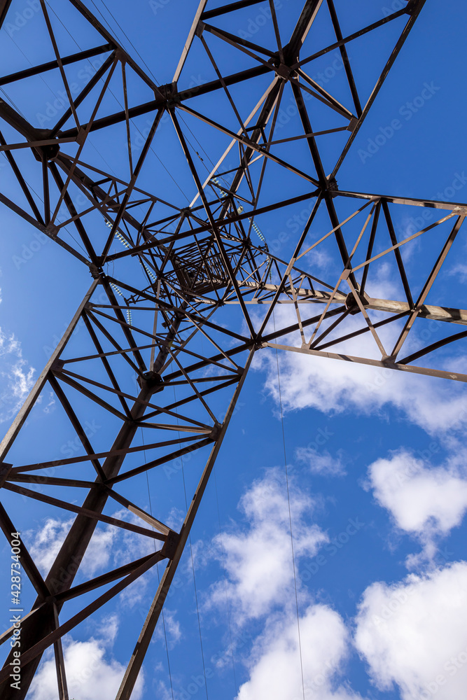 Power line towers against the blue sky. Wide viewing angle on the power line support. Power line towers against the blue sky. Wide viewing angle on the power line support.