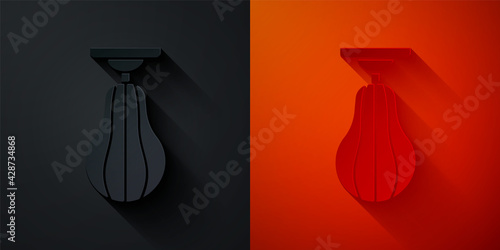 Paper cut Punching bag icon isolated on black and red background. Paper art style. Vector