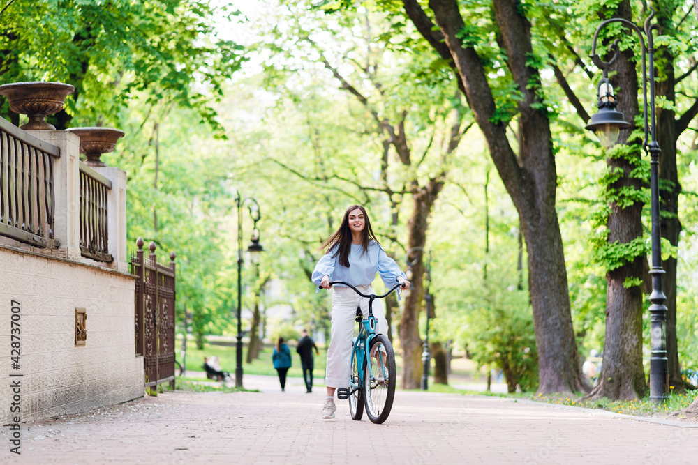 Young woman riding retro bike during warm day outdoors
