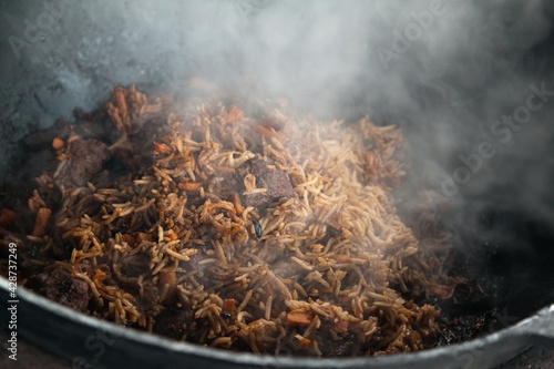 pilaf cooked in a cauldron on fire