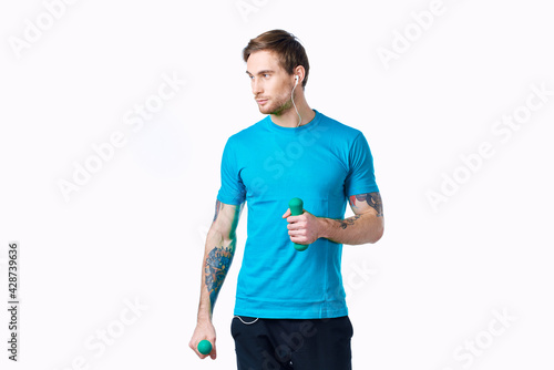 man with dumbbells in hands in headphones fitness exercise