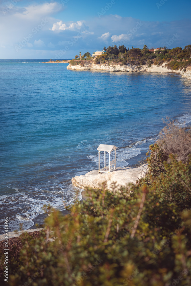 Beautiful small white bench on the Governor's beach near Limassol, Cyprus.