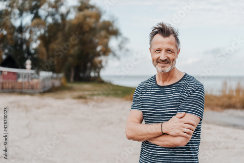 Trendy relaxed man posing on a deserted beach at dusk photo