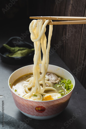 Bowl of homemade udon ramen, with eggs, meat, carrots, leeks and noodles