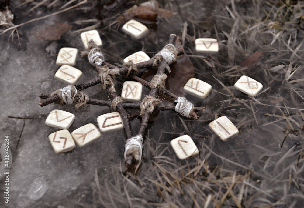 Fototapeta premium Still life with pentagram and wooden runes in the water outside. Esoteric, gothic and occult background, Halloween mystic and wicca concept outdoors.