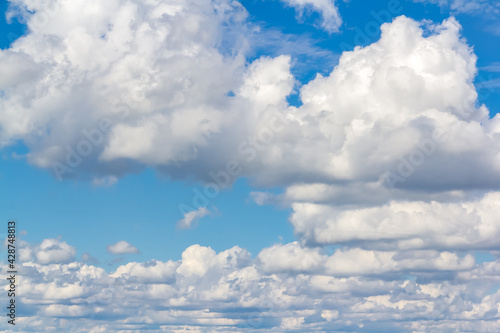 Blue sky with white fluffy clouds background.