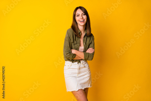 Photo of charming girl crossed hands laugh wear green shirt short skirt isolated yellow color background