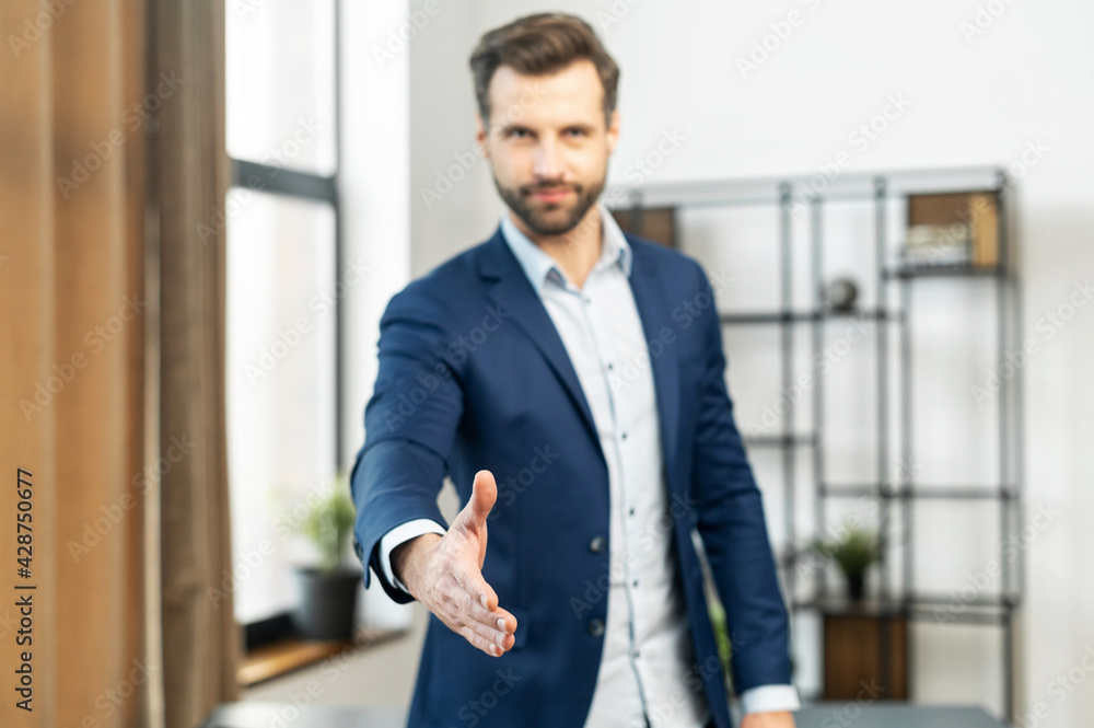 Confident businessman in blur, focus on the hand of businessman, dressed in suit, handshake for concluding the deal, ending of successful negotiate, hand shake with partner to celebration partnership Confident businessman in blur, focus on the hand of businessman, dressed in suit, handshake for concluding the deal, ending of successful negotiate, hand shake with partner to celebration partnership