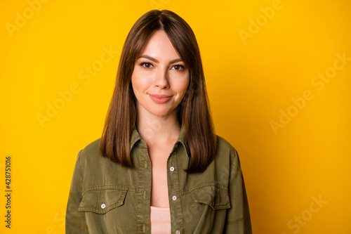 Photo of charming young girl positive cheerful look camera wear green shirt isolated yellow color background © deagreez