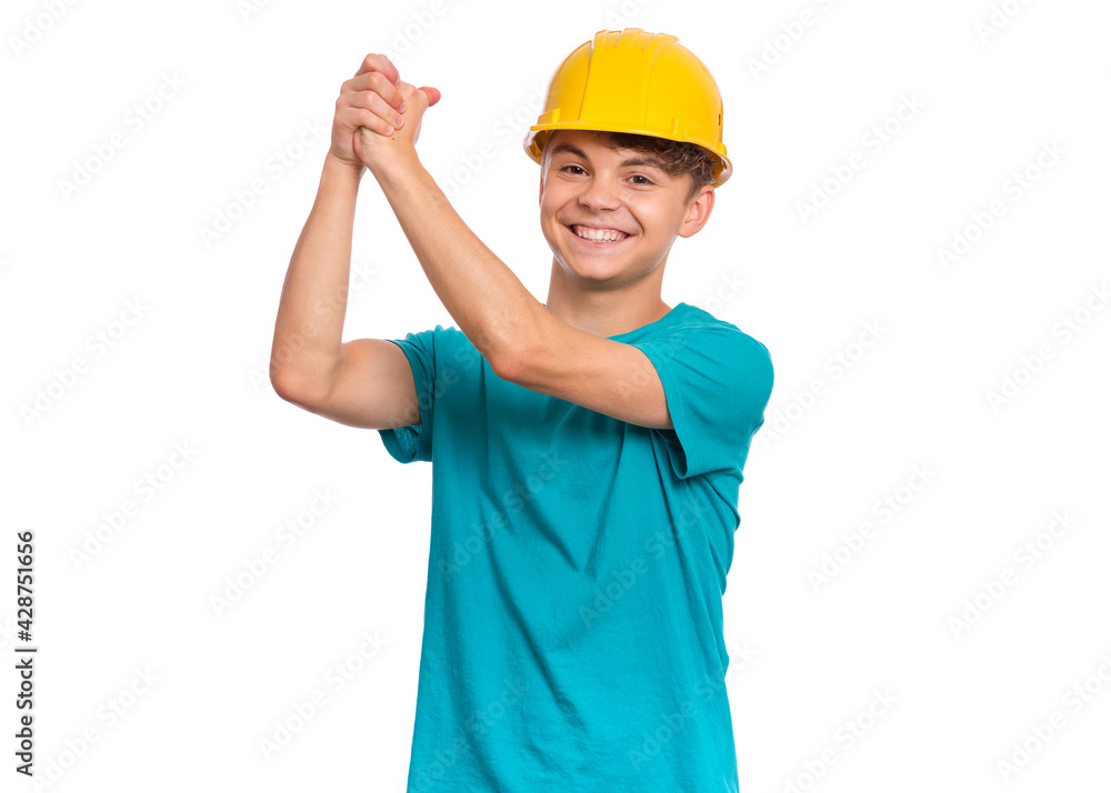 Portrait of confident smiling teen boy wearing yellow hard hat, isolated on white background. Beautiful student caucasian young teenager in helmet looking at camera