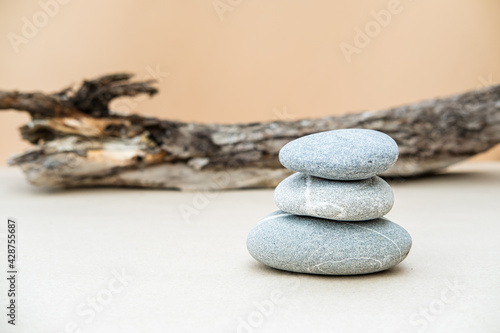 Pile of gray stones on background of big log. Natural components concept. Place for text.