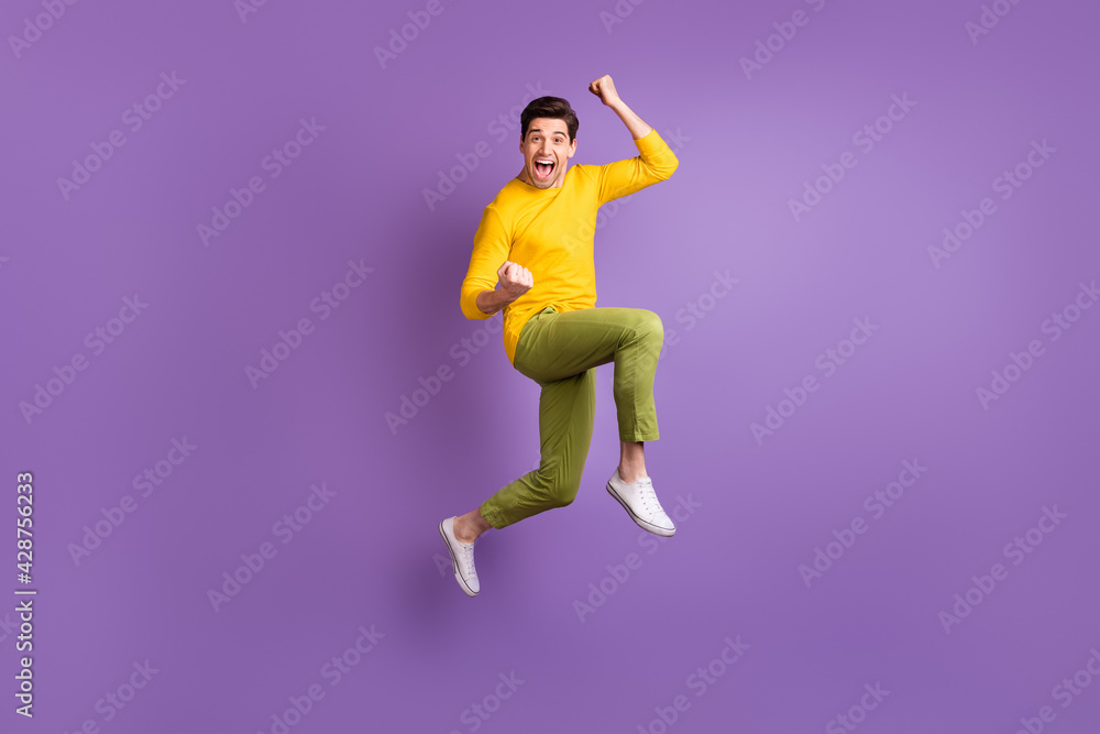 Fototapeta premium Full size photo of young happy excited crazy positive smiling man jumping in success victory isolated on violet color background